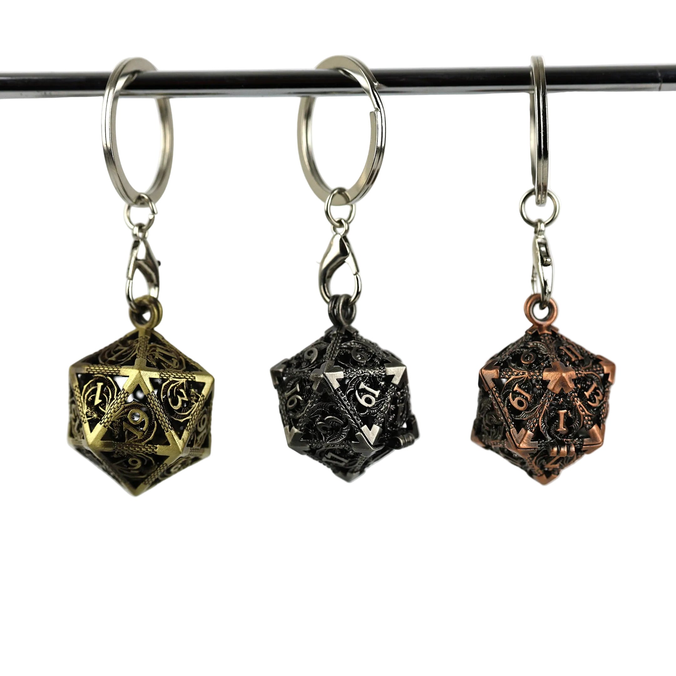 Three dice-shaped keychains hanging on a rod against a white background